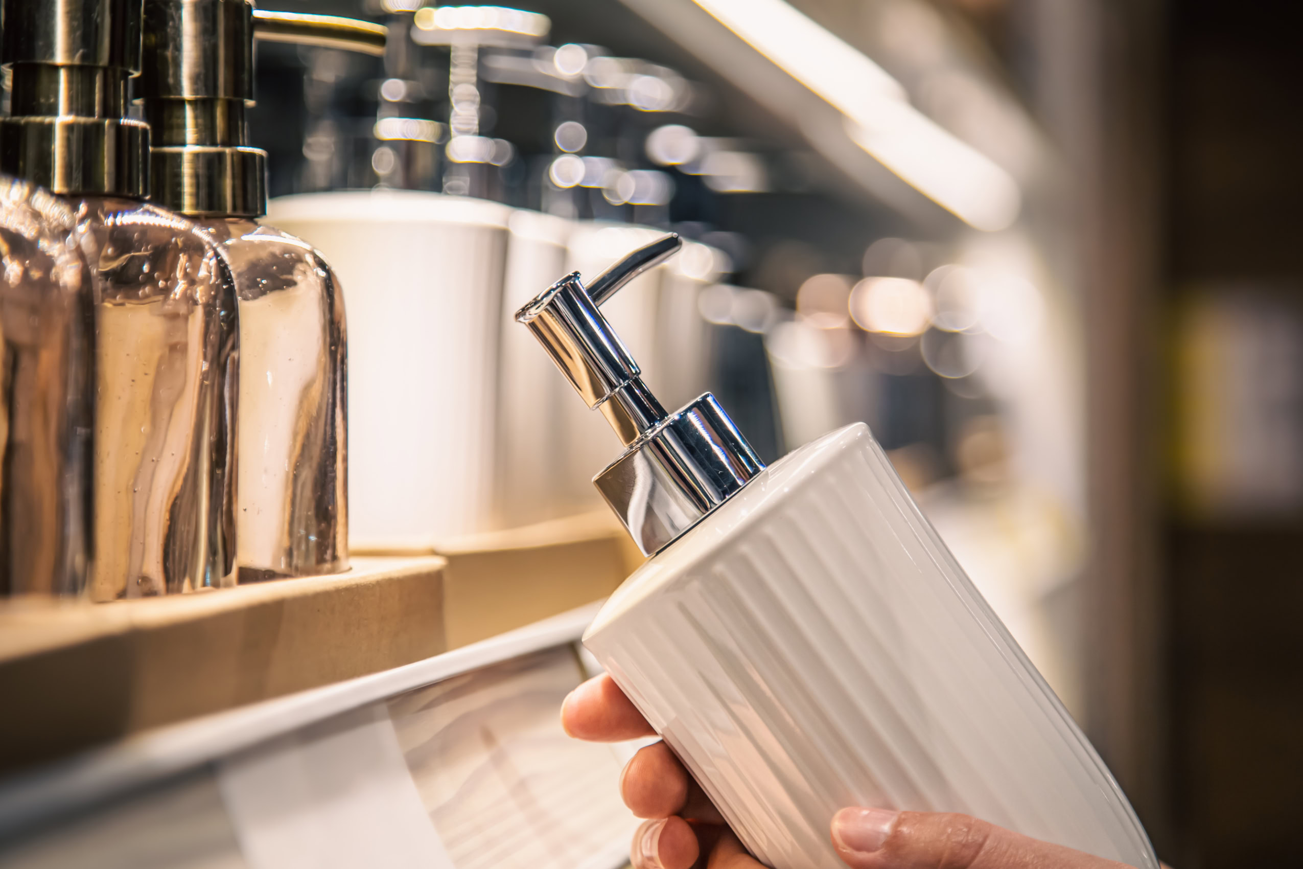 close up, a dispenser for liquid soap in female hands in the store.
