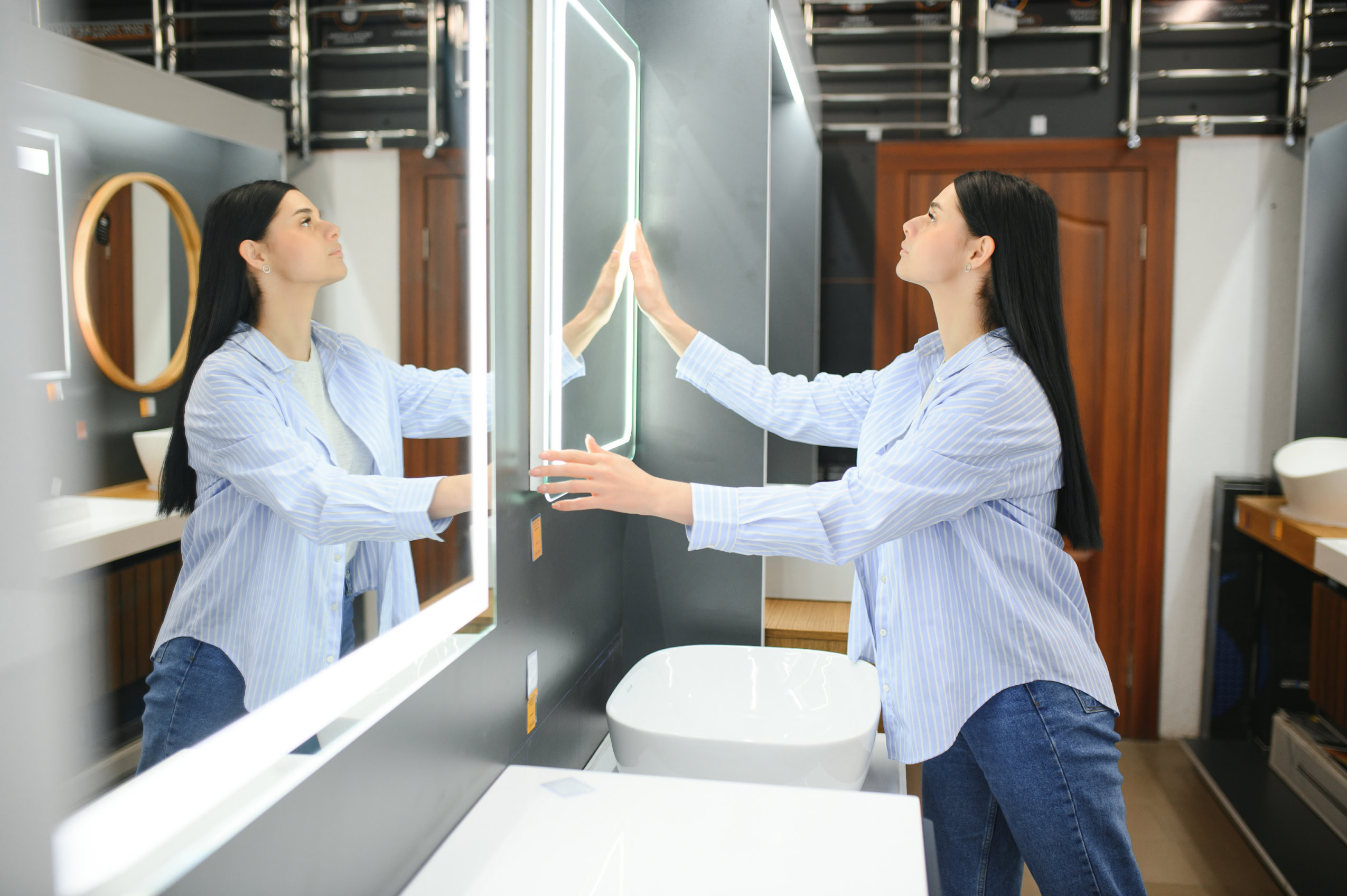 young woman choosing new bathroom furniture at the plumbing shop with lots of sanitary goods